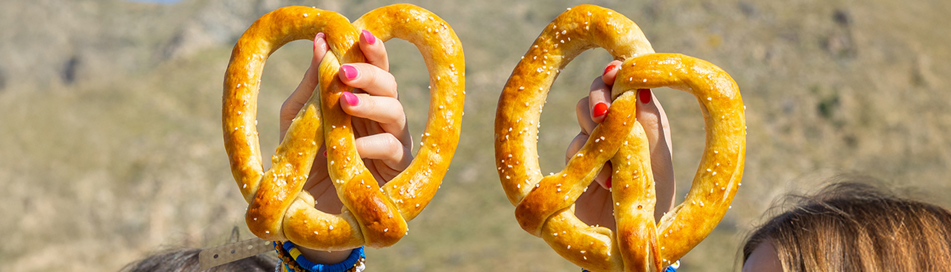 Two pretzels held by hands